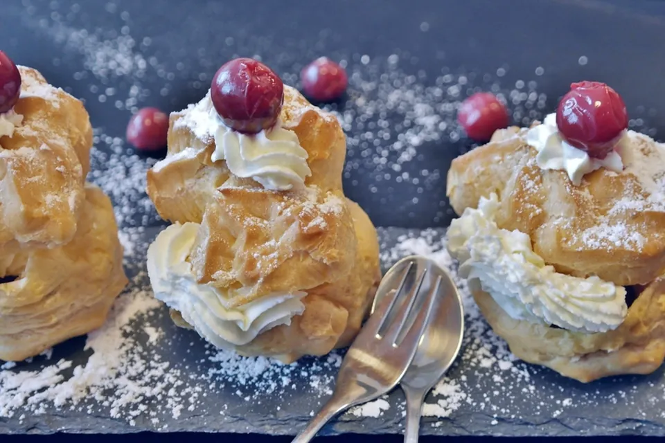 Cream puffs filled with whipped cream and topped with cherries