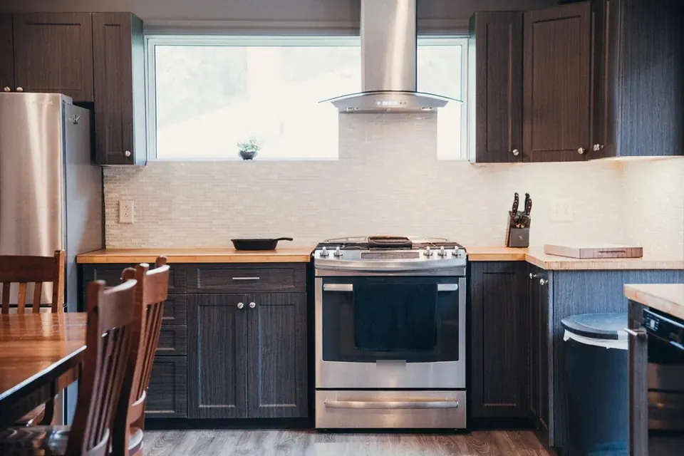 A stainless steel range with a hood above in a home kitchen
